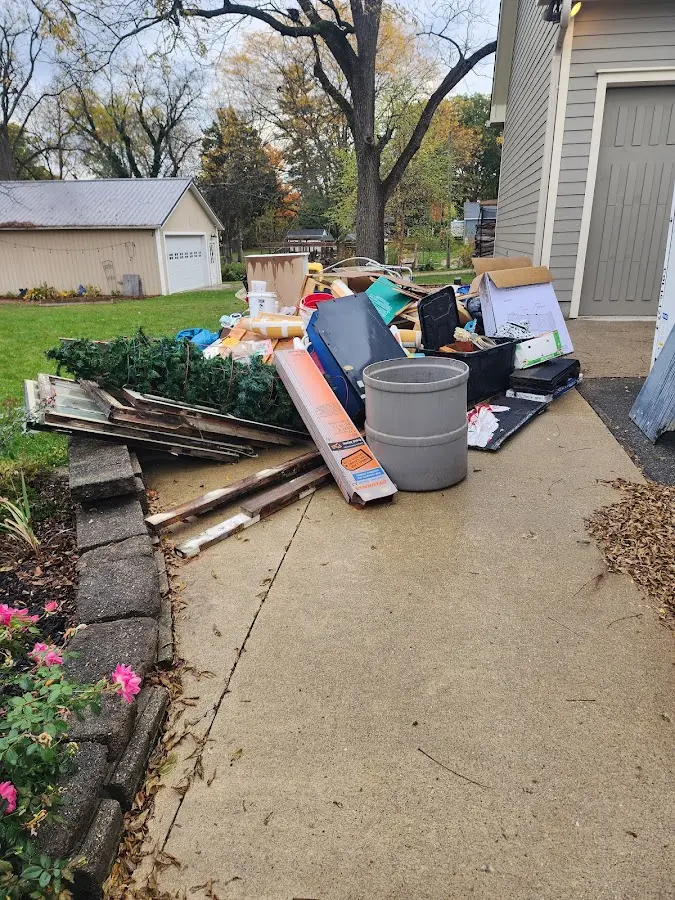 Dumpster being loaded with debris for Estate Cleanout Dumpster Rental in North Oaks